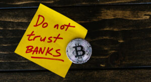 A sticky note stating do not trust banks, showing a symbol of bitcoin. Showing the importance of Blockchain Technology.